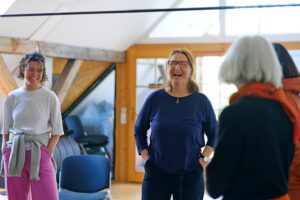 ursula scribano mit zwei klientinnen im stimmcoaching herzlich lachend